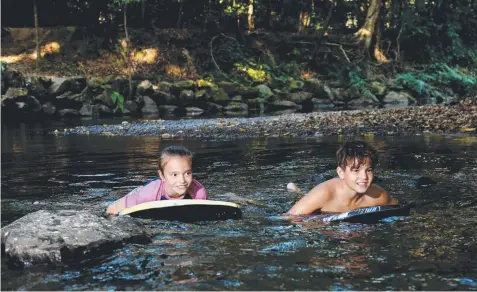  ??  ?? ACTIVITIES: Tilly, 9, and Koddi Brooks, 12, keeping cool in Freshwater Creek at Goomboora Park. Picture: STEWART McLEAN