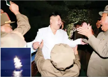  ?? KCNA VIA KNS/AFP ?? North Korean leader Kim Jong-un (centre) laughs as he inspects the test-fire of a strategic submarinel­aunched ballistic missile at an undisclose­d location; (inset) Wednesday’s missile launch.
