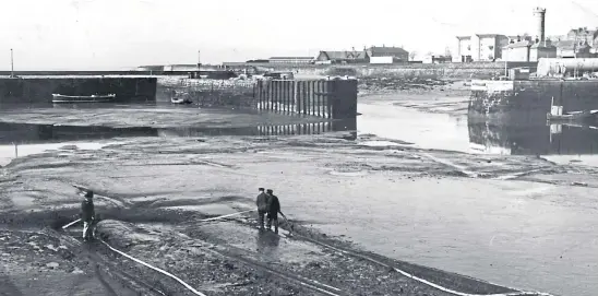  ??  ?? Proof that things were not always better in “the good old days”, this picture from April 1967 shows the slipway on the outer harbour at Arbroath being hosed to remove sludge, while the rest of the area was clearly undredged and useless for navigation at low tide.