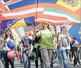  ?? [ALIK KEPLICZ/THE ASSOCIATED PRESS] ?? Young people carry flags of varying European countries during the yearly Schumann Parade in Warsaw on Saturday. Meanwhile, thousands of Poles rallied in a large square to protest the policies of the populist ruling party under Jaroslaw Kaczynski.