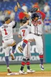  ?? AP PHOTO/MATT SLOCUM ?? The Atlanta Braves’ Ozzie Albies, left, and Ronald Acuna Jr., right, celebrate after beating the Philadelph­ia Phillies 3-1 on Wednesday in Philadelph­ia.