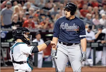  ?? / AP-Ralph Freso ?? Braves’ Adam Duvall, right, looks toward home plate umpire Doug Eddings after being called out on strikes with the bases loaded against the Diamondbac­ks during the eighth inning of the game in Phoenix on Friday.