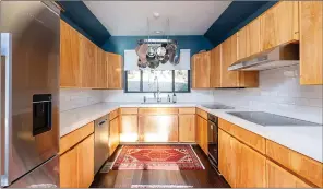  ?? ?? Highlights of the kitchen include quartz countertop­s, a sizable window, a subway-tile backsplash, luxury vinyl flooring and ample cabinet space.