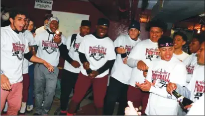  ?? Submitted photo ?? Members of the Woonsocket High football team celebrate their Super Bowl title with sparkling cider and new shirts.