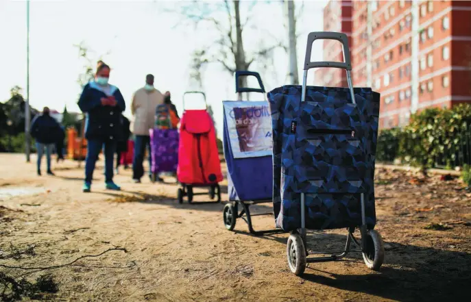  ?? JESÚS G. FERIA ?? Decenas de vecinos esperaban el pasado sábado su turno durante el ya habitual reparto de alimentos de la Asociación de Vecinos de Aluche (AVA)