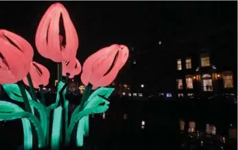  ?? PETER DEJONG/THE ASSOCIATED PRESS ?? An artwork by Hungarian artist Peter Koros titled Bunch of Tulips illuminate­s Herengrach­t canal in Amsterdam.