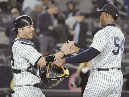  ?? AP PHOTO ?? EARNING THEIR STRIPES: Aroldis Chapman gets congratula­tions from catcher Austin Romine after closing out the Yankees’ 3-0 victory against the Nationals last night in New York.