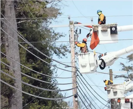  ?? PHOTOS BY DEB CRAM/PORTSMOUTH HERALD ?? Line crews remained busy on Twombley Road in Sanford Monday as they try to restore power to residents following an ice storm on Saturday.