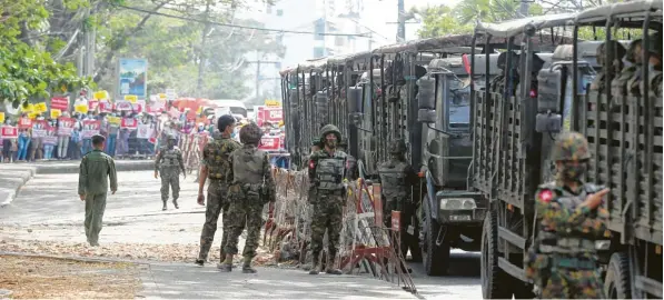  ?? Foto: Uncredited/AP/dpa ?? Spannung liegt in der Luft: Demonstran­ten, die in Yangon die Rückkehr des Militärs in die Kasernen fordern, und Soldaten stehen sich in Rufweite gegenüber.