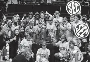  ?? Sam Craft / Associated Press ?? The Texas A&M women’s basketball team was the picture of happiness after winning the SEC regular-season championsh­ip following a victory over South Carolina on Sunday.