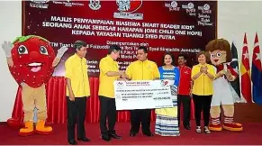  ??  ?? Ong (second from left) presenting the National One Child One Hope scholarshi­p to Tuanku Syed Faizuddin (third from left). With them are Tuanku Lailatul Shahreen (fourth from left) and Wang (right).