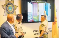  ?? ADOLPHE PIERRE-LOUIS/JOURNAL ?? From left, Bernalillo County Sheriff’s Office Sgt. John Allen, Chief Deputy Ray Chavez and Sheriff Manuel Gonzales examine where bullets hit a day care center Aug. 6.