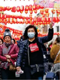  ??  ?? Masked: Tourists in Chinatown, London, yesterday