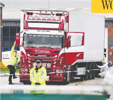  ?? LEON NEAL / GETTY IMAGES ?? Police and forensic officers investigat­e a truck after 39 bodies were discovered in the trailer near London Wednesday. The investigat­ion is focused on human traffickin­g as the trailer arrived in the U.K. from Belgium, according to police.