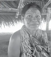  ??  ?? A member of the Dessena tribe poses for a picture in her village outside Manaus. The 100 people in the village live as they have for centuries, in small huts without electricit­y or running water.