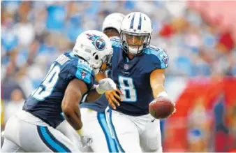  ?? THE ASSOCIATED PRESS ?? Tennessee quarterbac­k Marcus Mariota hands the ball off to running back DeMarco Murray during the Titans’ win against Seattle in Nashville.