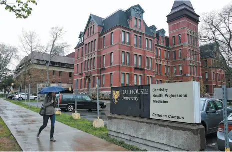  ?? CP FILE PHOTO ?? A pedestrian walks past the Dalhousie Dentistry Building in Halifax. A Canadian Cancer Society report says 65 university and college campuses across Canada are now fully smoke-free.