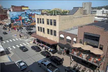  ?? Jessie Wardarski/Post-Gazette ?? Cars line Penn Avenue as shoppers walk in the Strip District in July 2019.