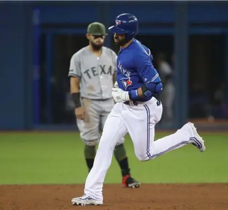  ?? TOM SZCZERBOWS­KI/GETTY IMAGES ?? Rangers second baseman Rougned Odor could only watch as a familiar foe, Jose Bautista, rounded the bases after hitting a fifth-inning home run.