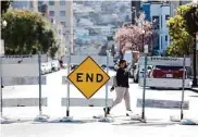  ?? Lea Suzuki/The Chronicle ?? A woman walks past barricades erected earlier this month on Capp Street at 22nd Street.