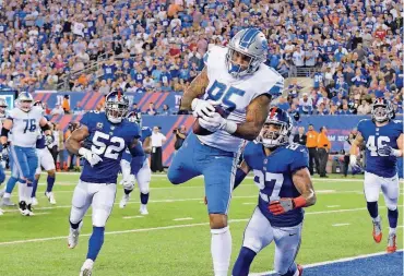  ??  ?? Detroit tight end Eric Ebron catches a touchdown pass in front of New York’s Darian Thompson, right, and Jonathan Casillas during Monday night’s game in East Rutherford, N.J. Detroit won the game, 24-10.