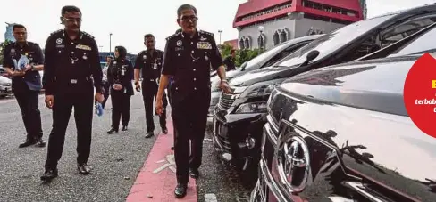  ??  ?? MAZLAN (kanan) menunjukka­n kereta mewah yang dirampas daripada kumpulan Ateng.