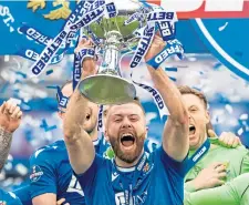  ??  ?? Shaun Rooney holds the Betfred Cup aloft.