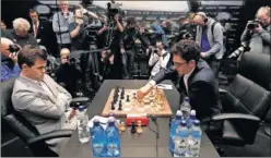  ??  ?? DUELO. Carlsen y Caruana se sientan hoy en esa mesa por última vez.