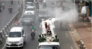  ??  ?? INDONESIA’s Red Cross personnel spray disinfecta­nt on the road to prevent the spread of the coronaviru­s disease 2019 (COVID-19) in Jakarta, Indonesia, March 28.