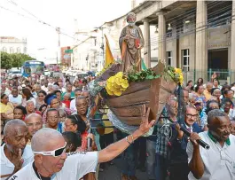  ??  ?? Fiéis carregam o andor com a imagem do santo pelas ruas do Centro