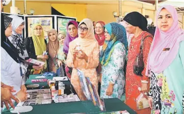  ??  ?? Fatimah (fourth right) visiting an exhibition booth after launching the seminar. — Photo by Chimon Upon