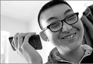  ?? ZHANG NAN / XINHUA ?? A visually impaired teenager listens to music on his cellphone in Changchun, Jilin province.