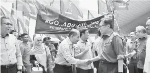  ??  ?? NAMA BERITA ? : Abang Johari (tiga kanan) begulai enggau Awang Tengah (dua kanan) sereta bala bukai rambau bejadika Pengawa Nyain Plak Ngengkahka Batu Pemun Ngaga Centexs Lawas.