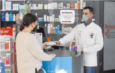  ?? // VALERIO MERINO ?? Una cliente pide un test de antígenos para hacerse la prueba del Covid en una farmacia de Córdoba