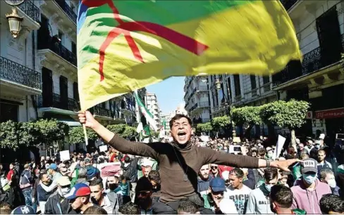  ?? AFP ?? An Algerian anti-government demonstrat­or waves an Amazigh (Berber) flag during a protest in the capital Algiers on Friday.