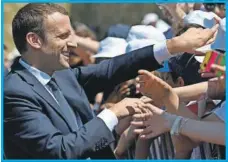  ??  ?? El presidente francés, Emmanuel Macron estrecha la mano con la gente durante una ceremonia
