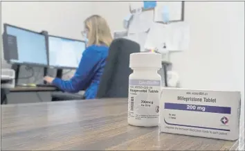  ?? JEFF ROBERSON — THE ASSOCIATED PRESS ?? A nurse practition­er works in an office at a Planned Parenthood clinic where she confers via teleconfer­ence with patients seeking self-managed abortions as containers of the medication used to end an early pregnancy sits on a table nearby last month in Fairview Heights, Ill.