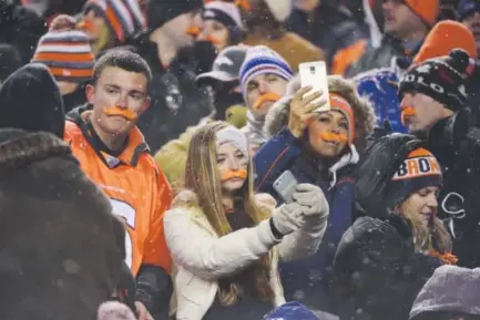  ??  ?? Broncos fans sporting orange mustaches take selfies during Denver’s game against New England at Sports Authority Field at Mile High on Nov. 29. Those with Verizon phones would’ve seen the fastest speeds. AAron Ontiveroz, The Denver Post