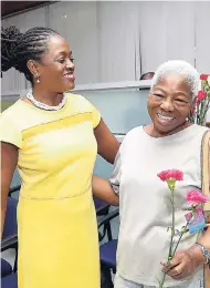  ?? CONTRIBUTE­D ?? Sagicor Bank CEO Chorvelle Johnson (left) happily greets a customer with flowers on Internatio­nal Women’s Day.