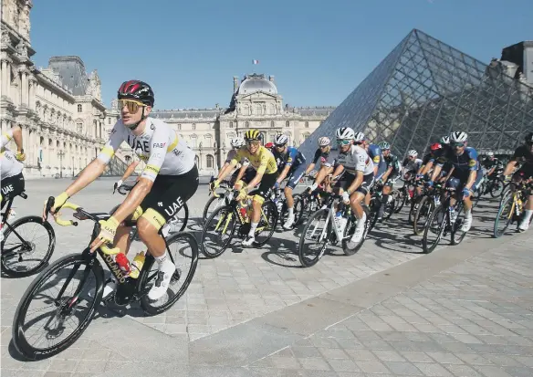  ??  ?? Team UAE Emirates' Tadej Pogacar wearing the overall leader's yellow jersey rides past the Louvre Pyramid inside the museum courtyard during the last stage of the Tour de France.