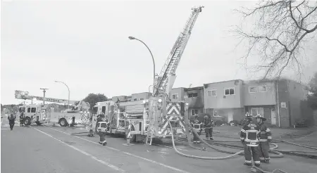  ?? PHOTOS BY ADRIAN LAM, TIMES COLONIST ?? Almost 12 hours after the fire broke out, firefighte­rs had yet to enter the razed units because of concern about their structural integrity.