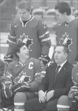  ??  ?? The newly named Team Canada Junior Mens team captain Ryan Nugent-Hopkins, front, spoke with teammates Griffin Reinhart, left, and Brett Ritchie as they suited up in their uniforms to take the official team photo at WinSport on Friday.