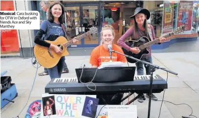  ??  ?? Musical Cara busking for OTW in Oxford with friends Ace and Sky Manthey