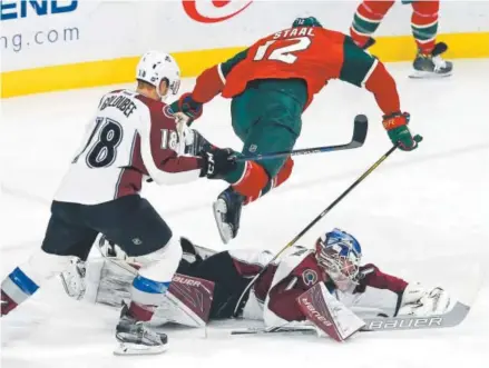  ??  ?? Avalanche goalie Semyon Varlamov makes a diving save as the Minnesota Wild’s Eric Staal jumps over him during the first period Tuesday night in St. Paul, Minn. Varlamov had 31 saves in Colorado’s 2-0 loss. Jim Mone, The Associated Press