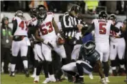  ?? CHRIS SZAGOLA — THE ASSOCIATED PRESS ?? The Falcons’ LaRoy Reynolds (53) reacts to his punt fumble recovery as Eagles returer Kenjon Barner (38) looks on during the first half last Saturday in Philadelph­ia. Philadelph­ia won 15-10.