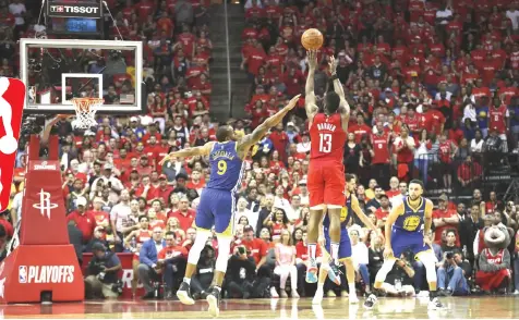  ?? — AFP photo ?? James Harden of the Houston Rockets takes a three point shot defended by Andre Iguodala (left) of the Golden State Warriors in overtime during Game Three of the Second Round of the 2019 NBA Western Conference Playoffs at Toyota Centre in Houston, Texas.