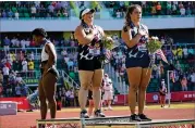  ?? CHARLIE RIEDEL/ASSOCIATED PRESS ?? Gwendolyn Berry looks away as Deanna Price and Brooke Andersen stand for the national anthem Saturday. Berry has promised to use her position in Tokyo to keep raising awareness about social injustices in her home country.