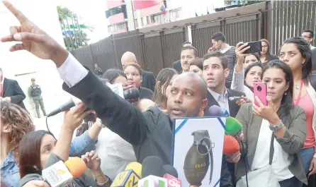  ?? — Reuters ?? A security officer of the Supreme Court shows an image of a type of grenade, which President Nicolas Maduro’s government says rogue policemen used to attack the Supreme Court and Interior Ministry after hijacking a helicopter, in Caracas on Friday.