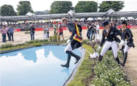  ?? FOTO: IMAGO ?? Sprung in den Wassergrab­en nach der Siegerehru­ng: Isabell Werth (r.) muss sich im Juni im Grand Prix Spécial der Deutschen Meistersch­aft in Balve im Sauerland Sönke Rothenberg­er (l.) geschlagen geben. Dritte wird Dorothee Schneider (M.).