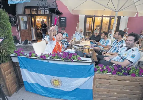  ??  ?? Distendido­s o en pleno aliento frente al hotel Ramada, donde están Messi y compañía, los hinchas argentinos se adueñaron de las calles de Kazán